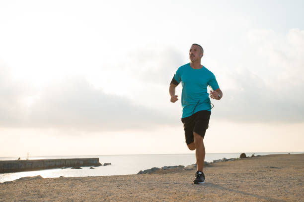istock Inspirited handsome sportsman running over beach 838172926