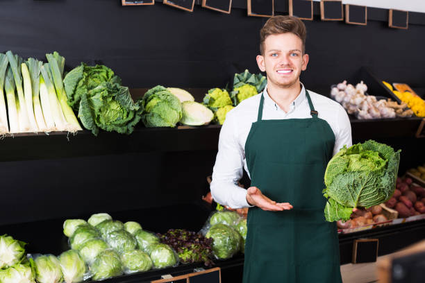 istock Seller showing cabbage in shop 838177264