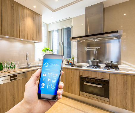 mobile phone with smart home app in modern kitchen