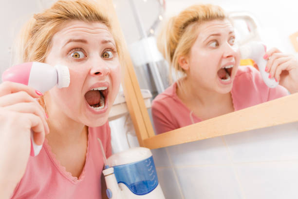 istock Shocked woman using facial cleansing brush 838189804