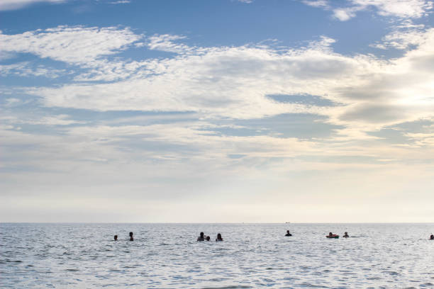 istock People in the sea with blue sky and sunlight 838190350