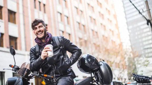 Urban man sitting on his motorcycle and having a break in the city