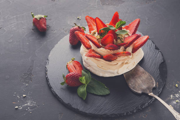 istock Anna Pavlova cake with strawberry on black background 838197582