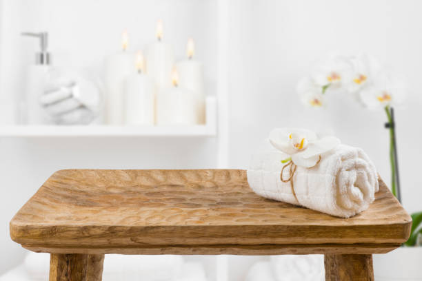 tavolo in legno con asciugamano spa su sfondo ripiano bagno sfocato - cotton white textured toiletries foto e immagini stock