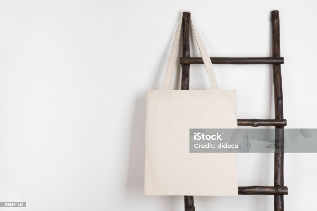 Fabric cloth shopping bag mockup hanging on vintage wooden stepladder Tote Bag Stock Photo