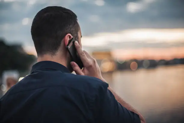 Photo of Businessman talking on mobile phone looking at city