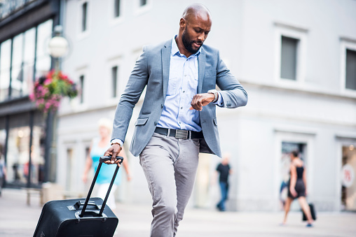 Businessman running through the city with luggage
