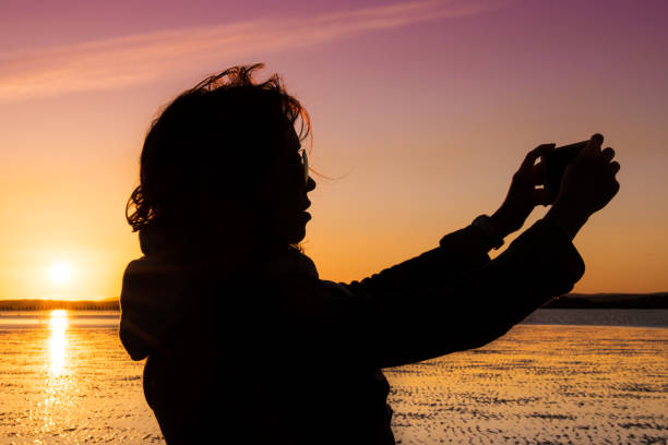 istock Beautiful young woman taking selfie on a beach during sunset. 838212940