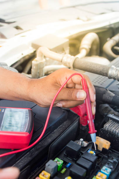 istock Auto mechanic uses a multimeter voltmeter to check the voltage level in a car battery. 838221796
