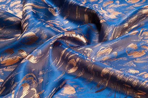 istock Fabric texture of silk with gold-painted flowers 838230144