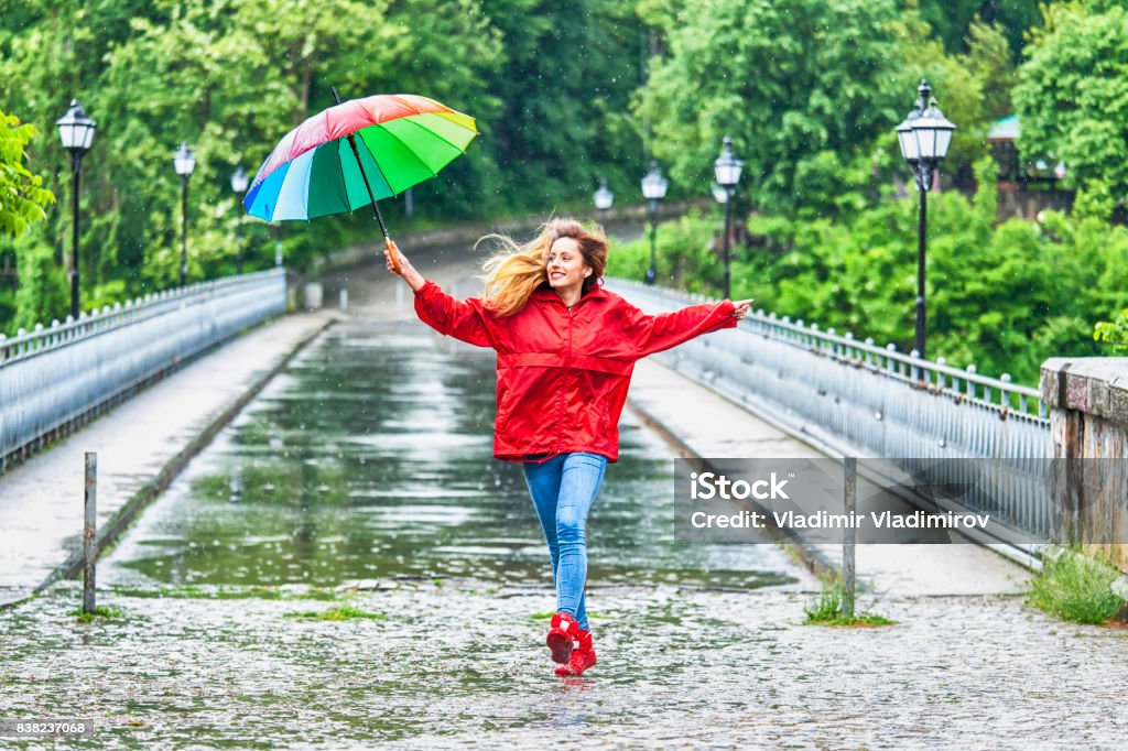 Beautiful girl with umbrella dancing in the rain Beautiful girl with umbrella dancing in the rain, on bridge. Rain Stock Photo