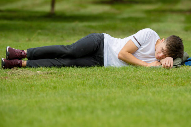 Teenage boy laying on grass on a summers day