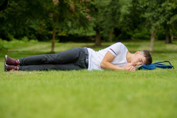 istock Teenage boy laying on grass on a summers day 838238398