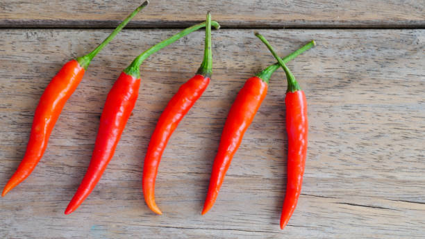 istock Fresh red chili pepper on wood texture. 838254982