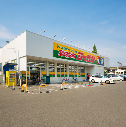 Sakaecho discount store in Takasaki Japan with front parking and cars and bicycles parked.