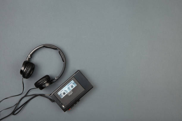 Retro cassette player with headphones on grey background