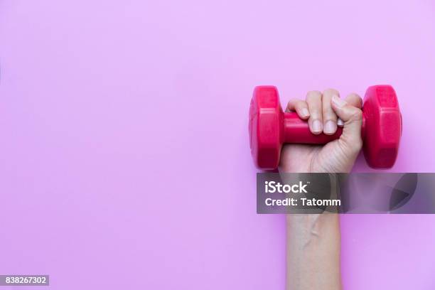 Woman Hand Holding Red Dumbbell On Pink Background Stock Photo - Download Image Now - Dumbbell, Exercising, Healthy Lifestyle