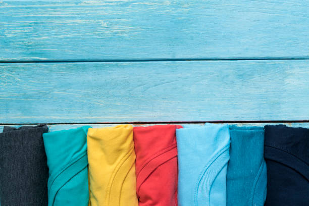 istock close up of rolled colorful clothes on blue table background 838267478