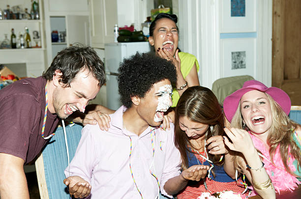 hombre con la cubierta de crema en la cara sonriente con amigos - birthday cake five people party fotografías e imágenes de stock