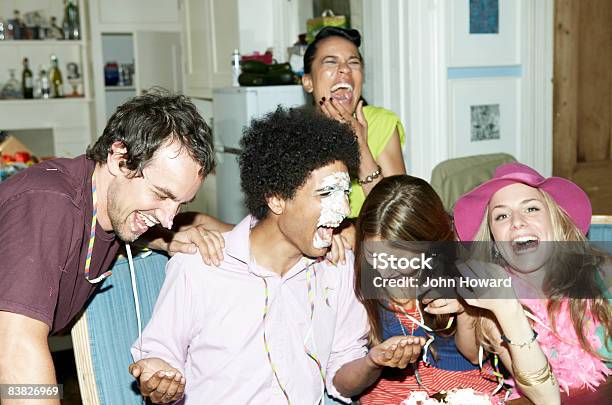 Man With Icing On His Face Laughing With Friends Stock Photo - Download Image Now - Party - Social Event, Humor, Birthday