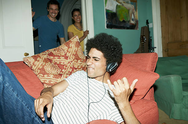 Man playing air guitar with friends watching  air guitar stock pictures, royalty-free photos & images