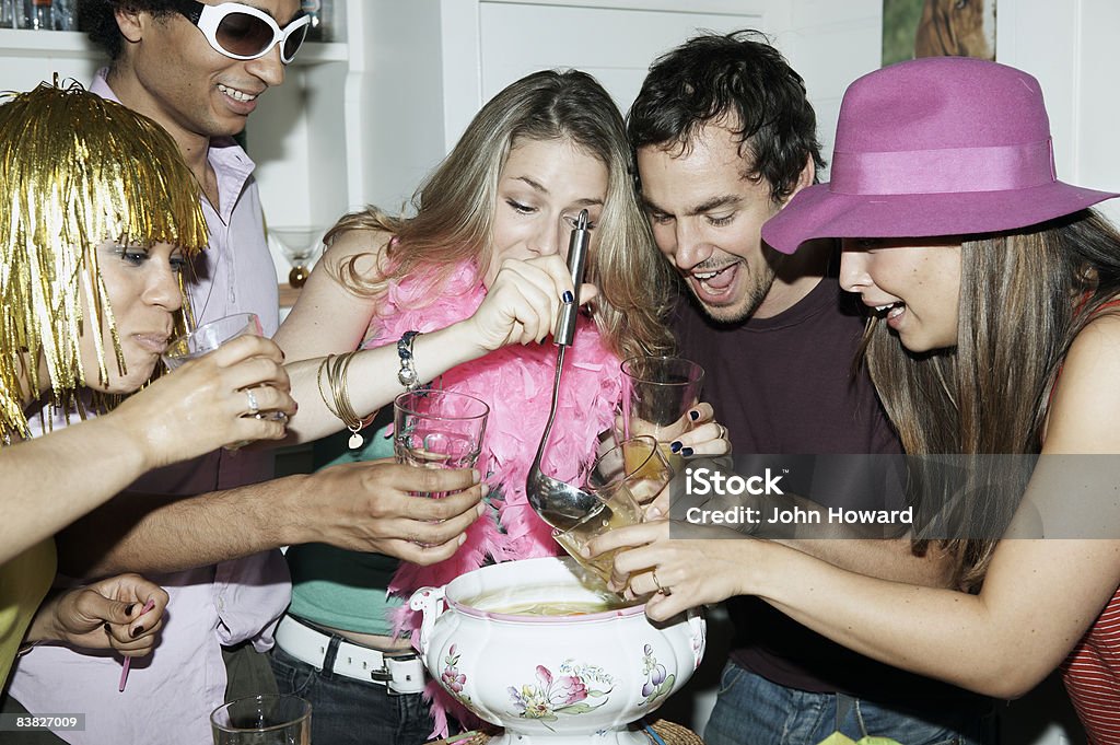 Friends pouring punch into glasses  20-24 Years Stock Photo