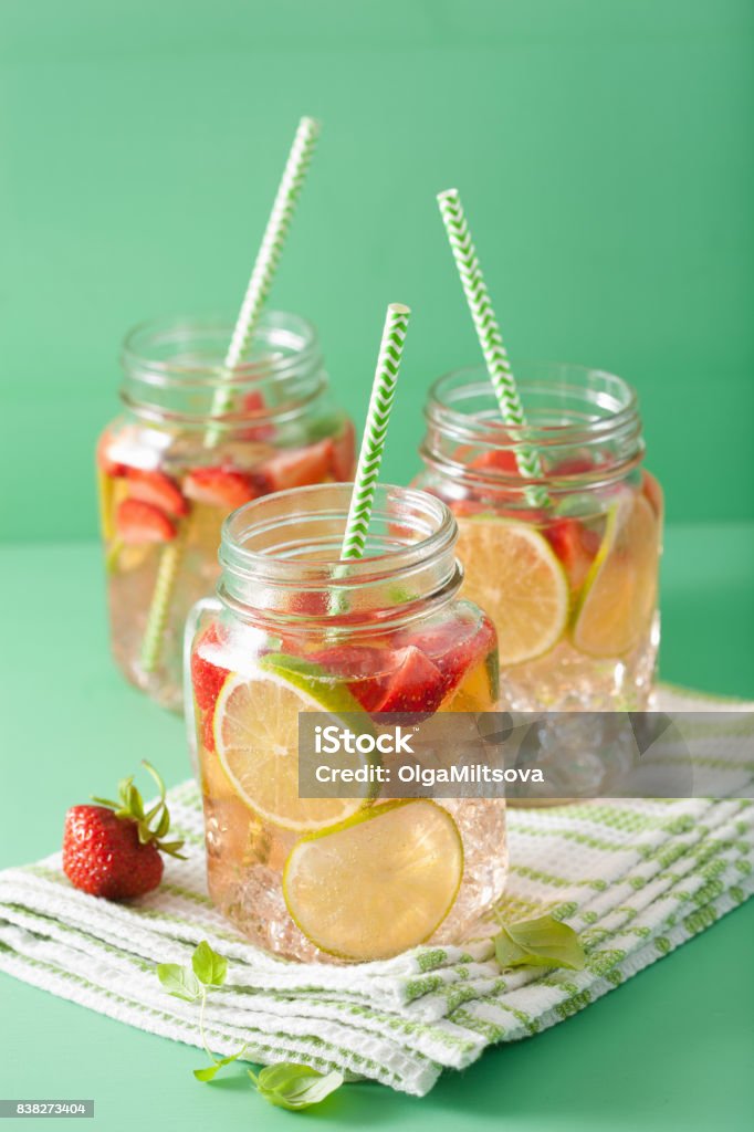 refreshing summer lemonade with strawberry and lime in mason jar Berry Stock Photo