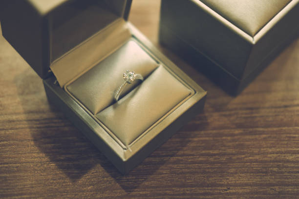 istock Two engagement ring in box on wood table 838277752