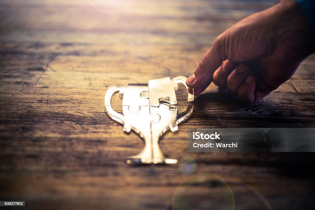 Earning the big trophy piece by piece Award Stock Photo