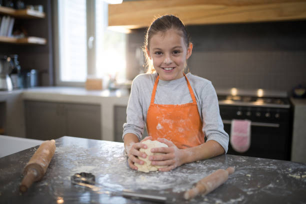 istock Little girl holding dough in her hand 838280284