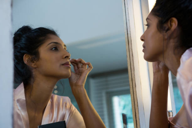 istock Woman applying makeup reflecting on mirror 838280634