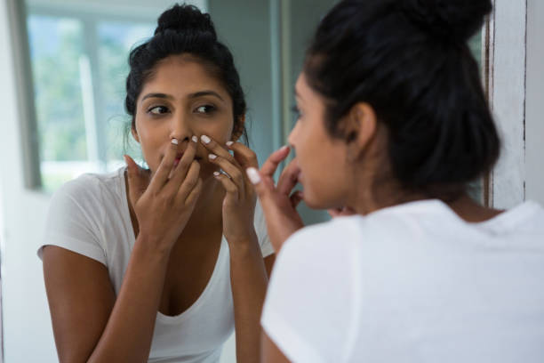 istock Woman squeezing pimple reflecting on mirror 838281402