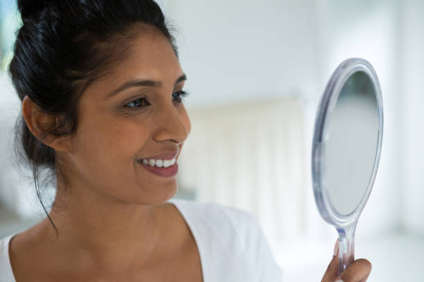 istock Smiling woman holding hand mirror 838282578