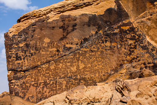 Neolithic graffiti art on a stand-alone rock in the desert
