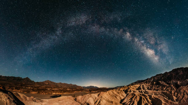 Stargazing in Death Valley Milky way raising over Zabriskie Point in Death Valley death valley desert photos stock pictures, royalty-free photos & images
