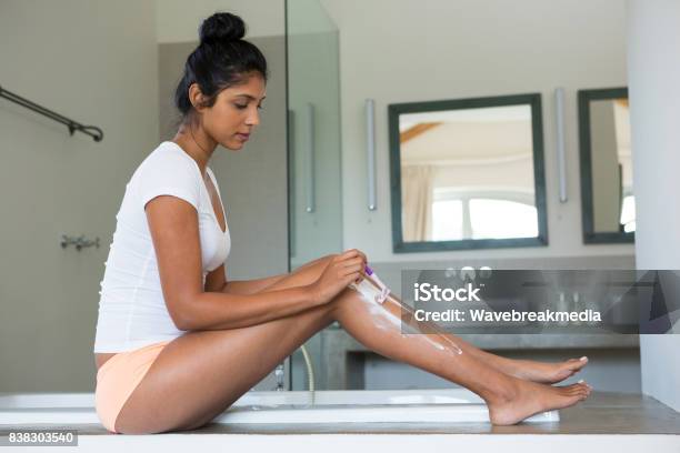 Full Length Of Woman Shaving Leg In Bathroom Stock Photo - Download Image Now - Shaving, Leg, One Woman Only