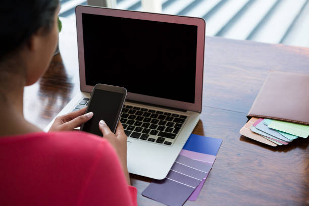 istock Woman with laptop using phone 838330910