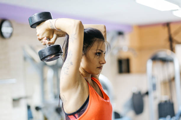 istock Young woman doing weight lifting in the gym 838331994