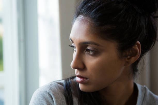 istock Close-up of woman looking through window 838336526
