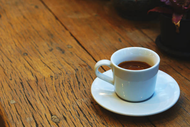 istock espresso coffee in white cup on old wooden table with copy space. 838337710