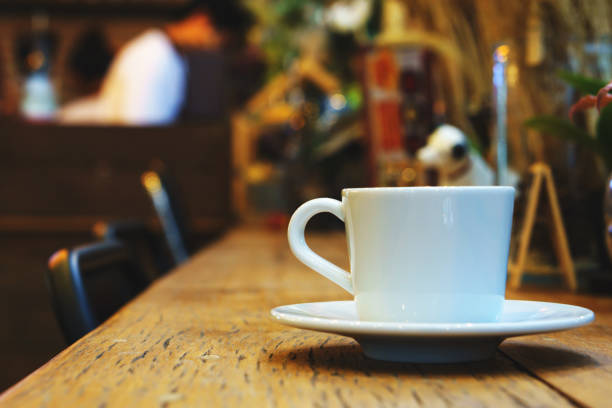 istock side view of espresso coffee in white cup on wooden table with blurred cafe background. copy space for text. 838337724