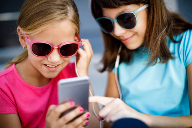 istock Two cute girls using smart phone and listening music 838341710