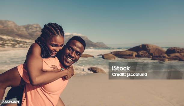 Young Couple Enjoying At The Beach Stock Photo - Download Image Now - Couple - Relationship, African Ethnicity, Beach