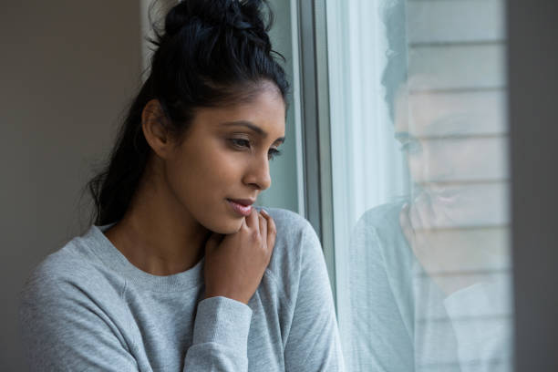 istock Thoughtful woman looking through window 838354144
