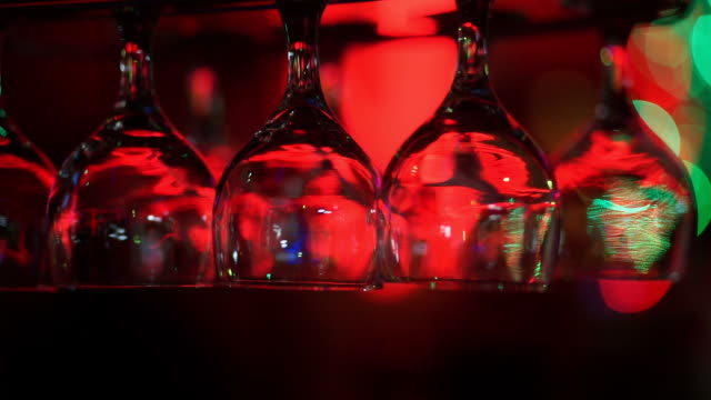 Empty wine glasses above a bar rack.
