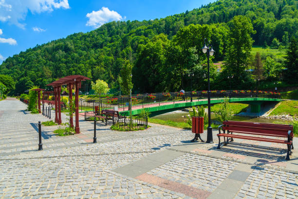 Promenade along a river Szczawnica village on sunny summer day, Beskid Niski Mountains, Poland Szczawnica is a well-known resort town since the mid nineteenth century. Due to the presence of alkali sorrel springs and favorable climatic conditions, many respiratory and digestive tract illnesses are treated there. szczawnica stock pictures, royalty-free photos & images