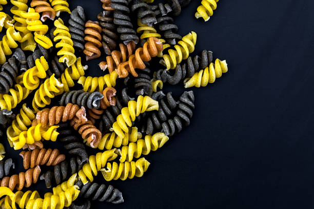 Uncooked pasta fusilli in different colours