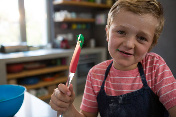 istock Portrait of boy holding spatula with batter 838356928