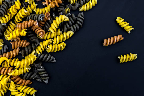 Uncooked pasta fusilli in different colours