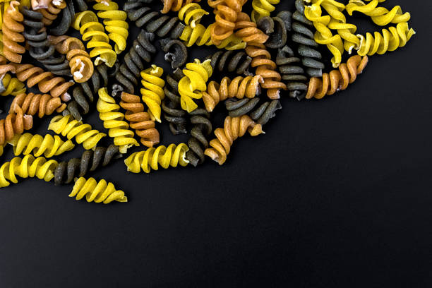 Uncooked pasta fusilli in different colours